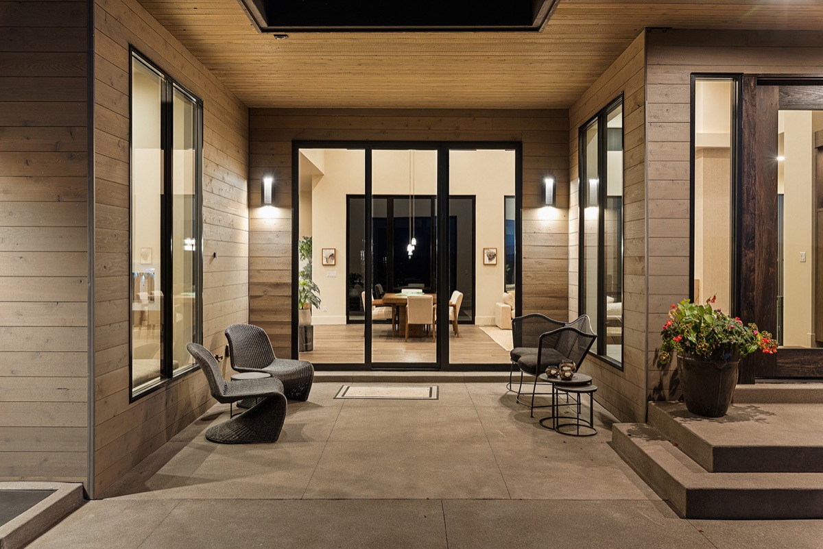 A luxury home patio at dusk with floor-to-ceiling glass doors from Quaker's Quartz division